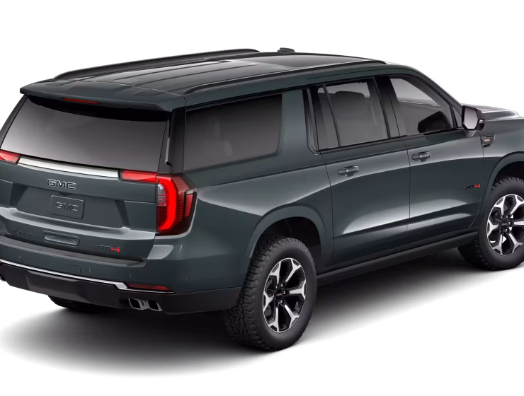 2026 GMC Yukon Denali XL AT4 Ultimate with the 6.2L V8 Petrol engine in striking Midnight Pine Metallic, featuring a premium Obsidian Rush interior with red accents and full-grain leather seating surfaces.