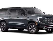 2026 GMC Yukon Denali XL AT4 Ultimate with the 6.2L V8 Petrol engine in striking Midnight Pine Metallic, featuring a premium Obsidian Rush interior with red accents and full-grain leather seating surfaces.