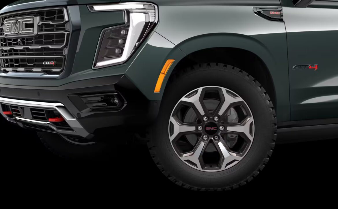 2026 GMC Yukon Denali XL AT4 Ultimate with the 6.2L V8 Petrol engine in striking Midnight Pine Metallic, featuring a premium Obsidian Rush interior with red accents and full-grain leather seating surfaces.