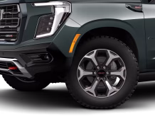 2026 GMC Yukon Denali XL AT4 Ultimate with the 6.2L V8 Petrol engine in striking Midnight Pine Metallic, featuring a premium Obsidian Rush interior with red accents and full-grain leather seating surfaces.