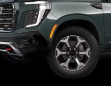 2026 GMC Yukon Denali XL AT4 Ultimate with the 6.2L V8 Petrol engine in striking Midnight Pine Metallic, featuring a premium Obsidian Rush interior with red accents and full-grain leather seating surfaces.