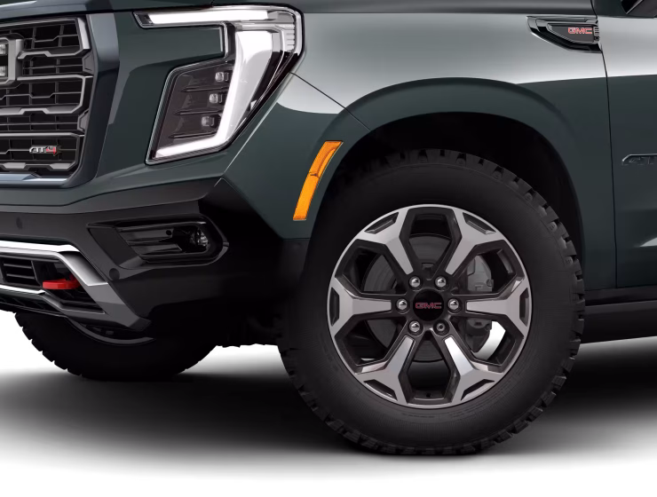 2026 GMC Yukon Denali XL AT4 Ultimate with the 6.2L V8 Petrol engine in striking Midnight Pine Metallic, featuring a premium Obsidian Rush interior with red accents and full-grain leather seating surfaces.