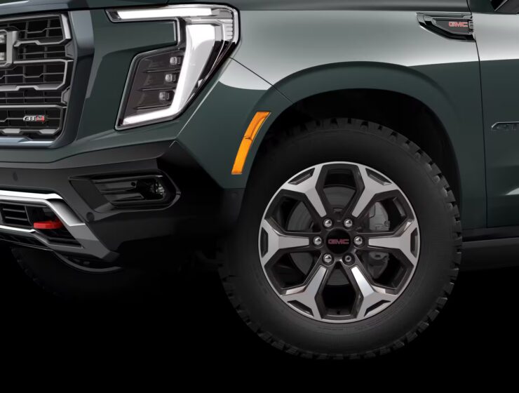2026 GMC Yukon Denali XL AT4 Ultimate with the 6.2L V8 Petrol engine in striking Midnight Pine Metallic, featuring a premium Obsidian Rush interior with red accents and full-grain leather seating surfaces.